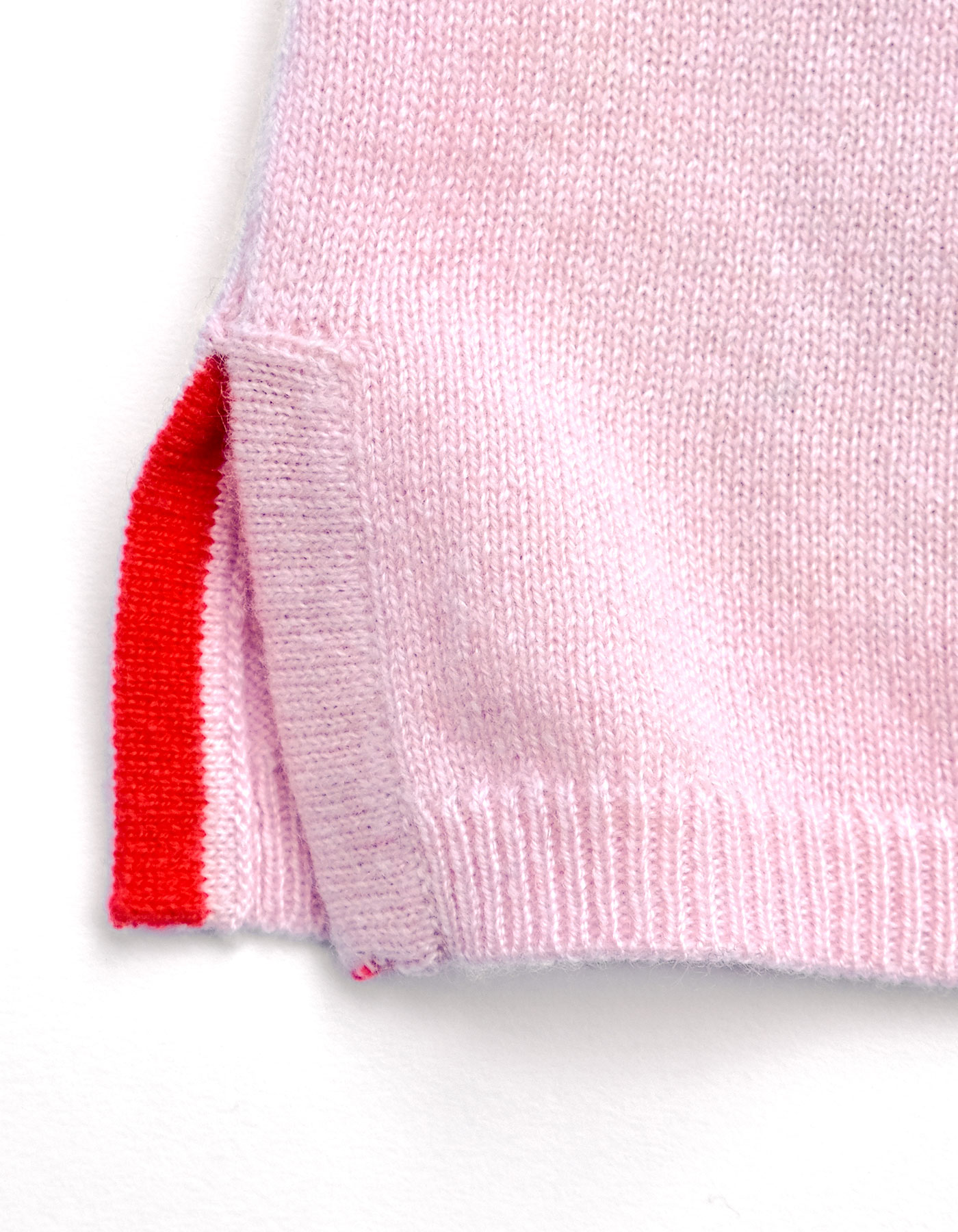Close up of the red and pink hem detail on a malin darlin pink cashmere jumper.