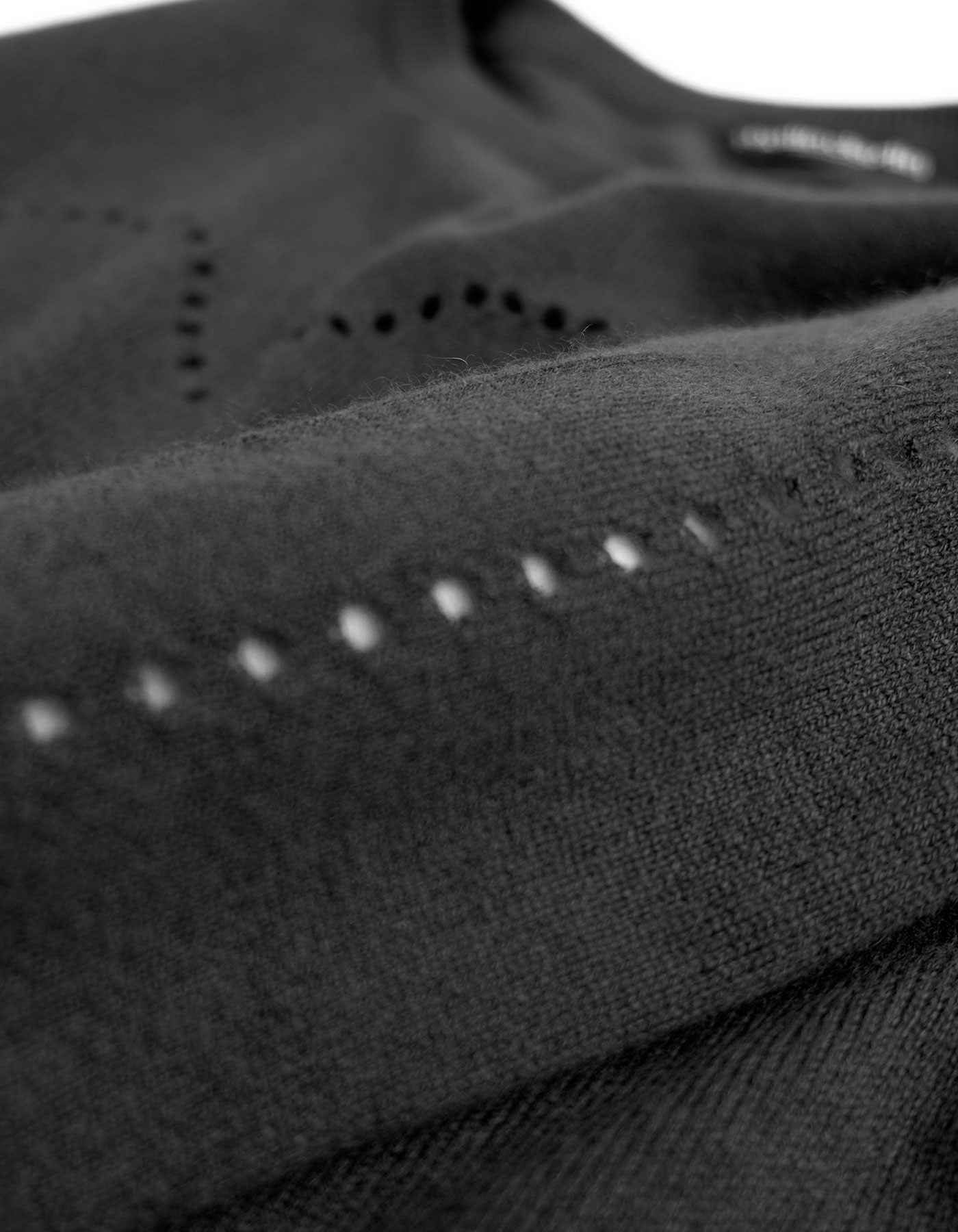 Zoomed detail of the heart hole pattern knitted into malin darlin cashmere knitwear.