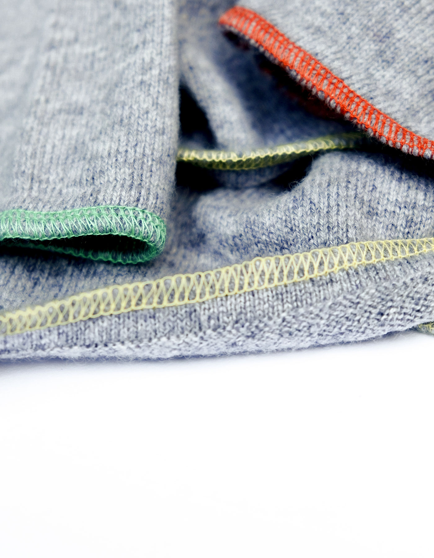 Hem detail of the Tie Hooded Cashmere Jumper by Malin Darlin showing yellow, green and red contrast stitch.