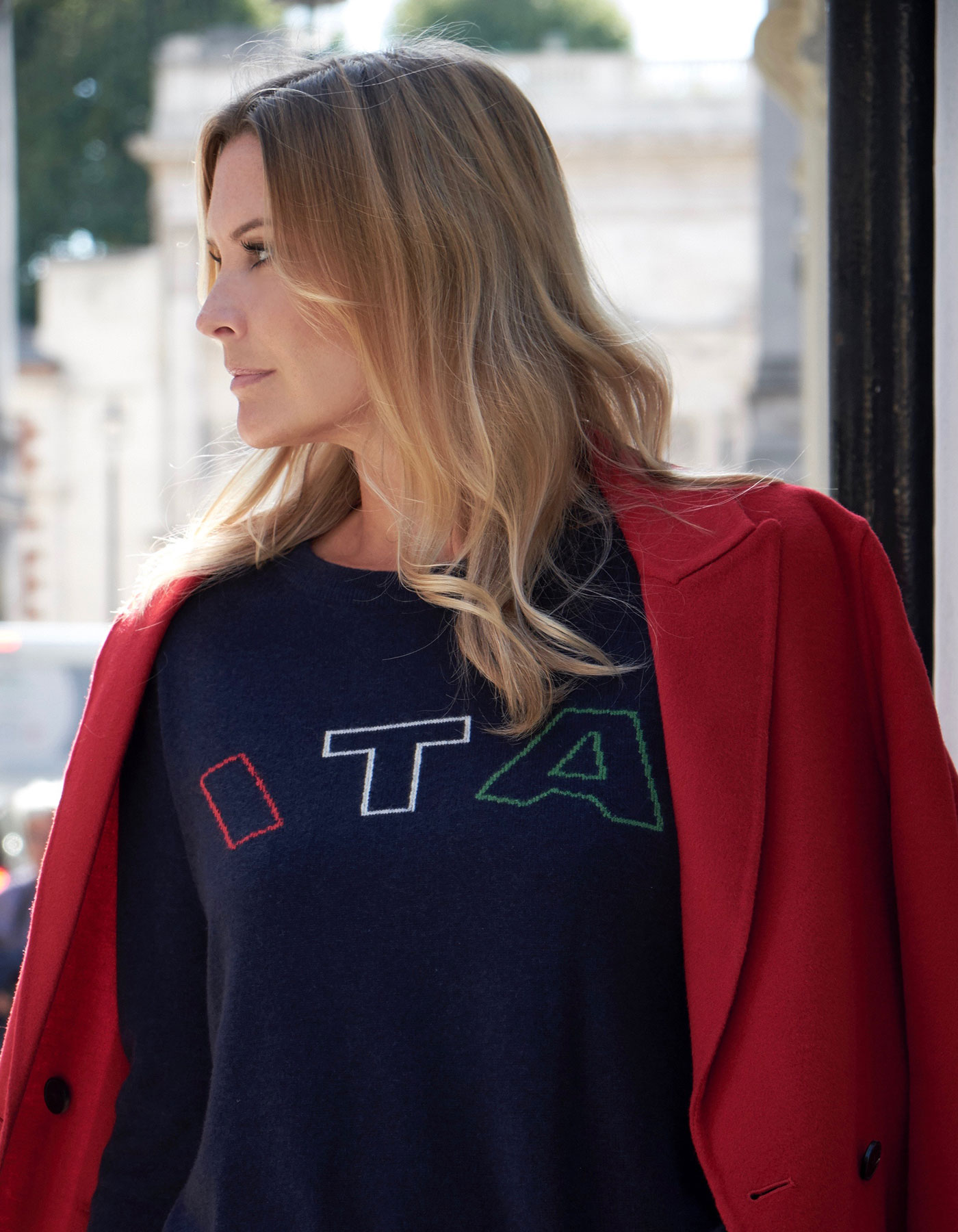 Photo of a woman with jacket over her shoulders wearing cashmere Knitwear, the malin darlin ITA designer cashmere jumper.