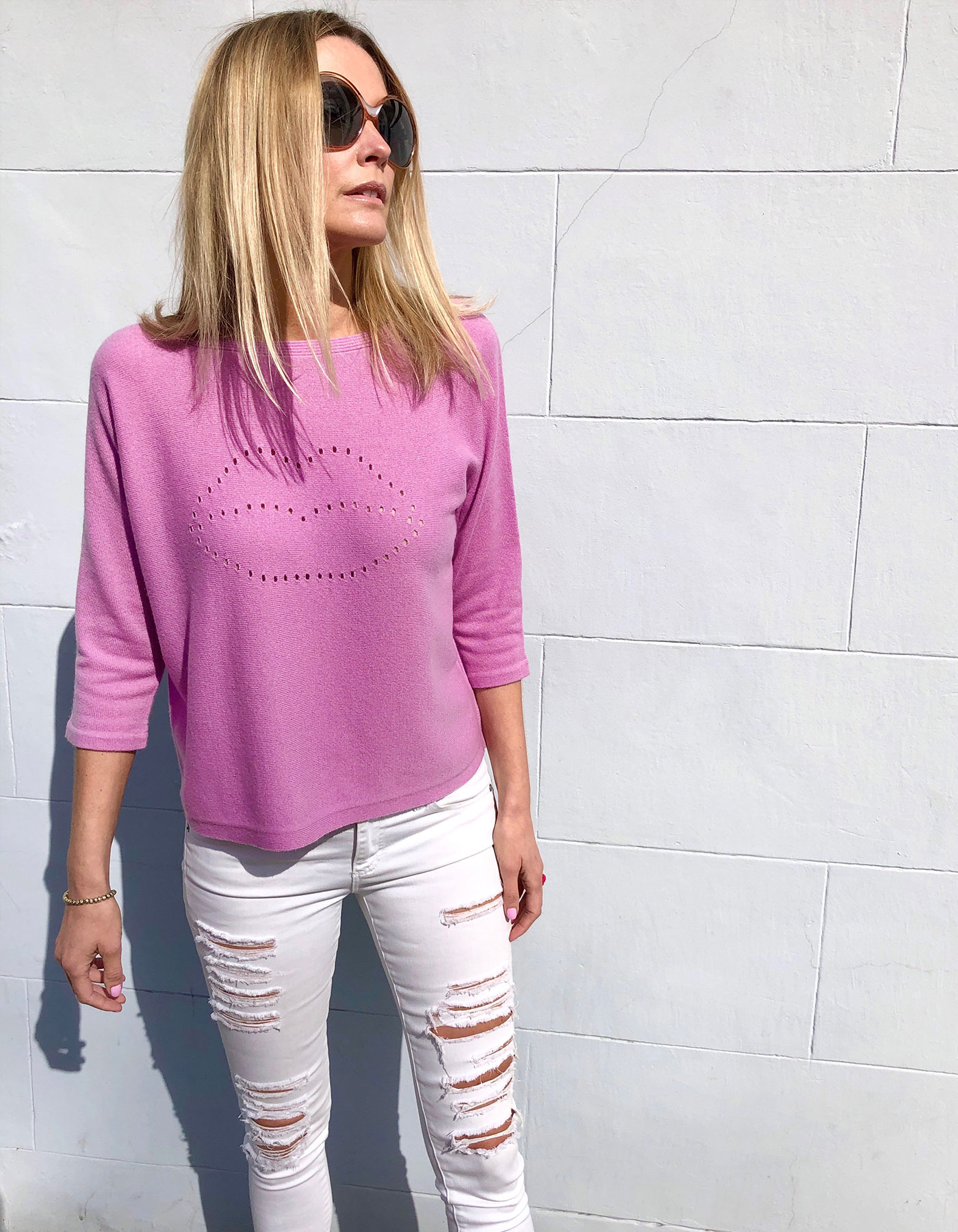 Model wearing ripped jeans and cashmere knitwear to promote malin darlin Lip Holes cashmere jumpers.